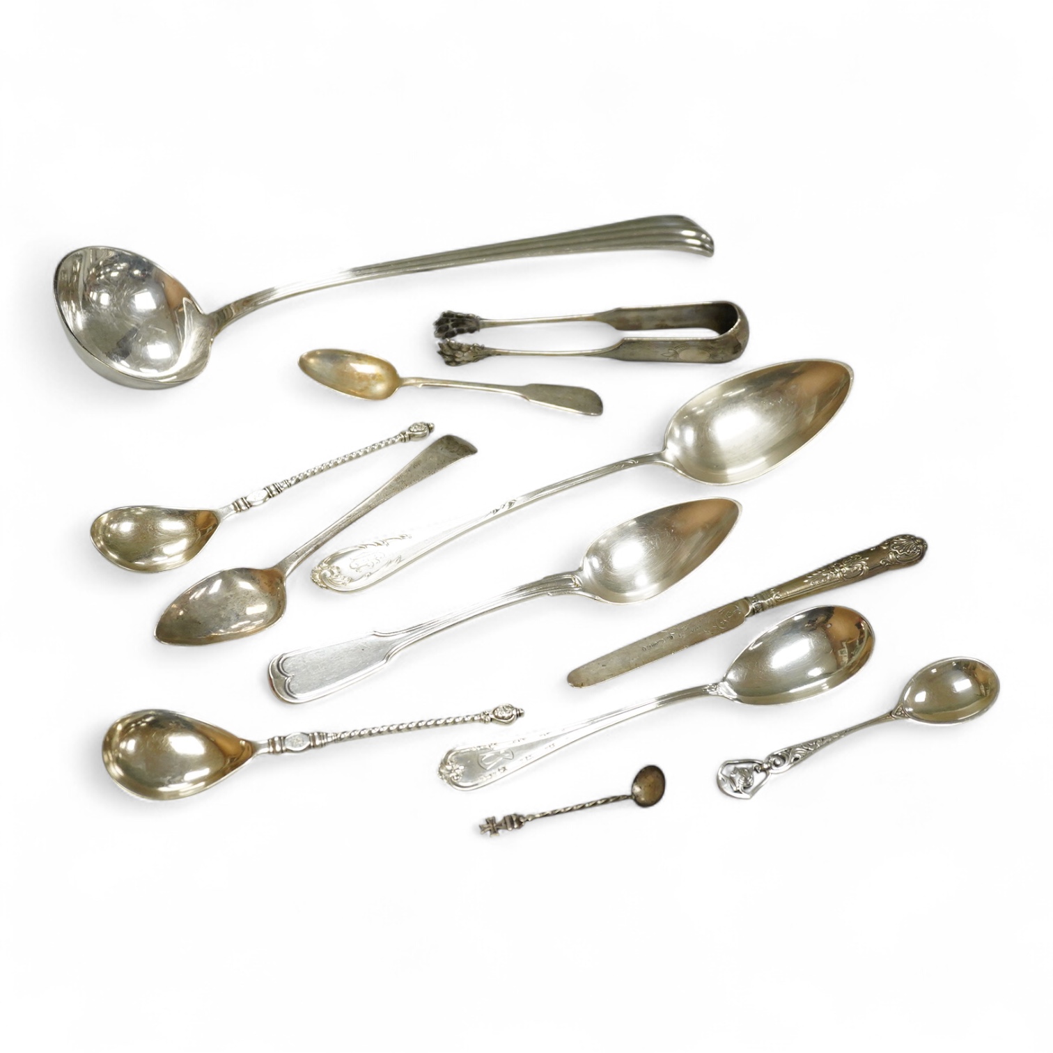 A George III silver Old English pattern dessert spoon, London, 1807, a later silver teaspoon and ten other items of white metal cutlery including a soup ladle, German tablespoon, pair of sugar tongs etc.